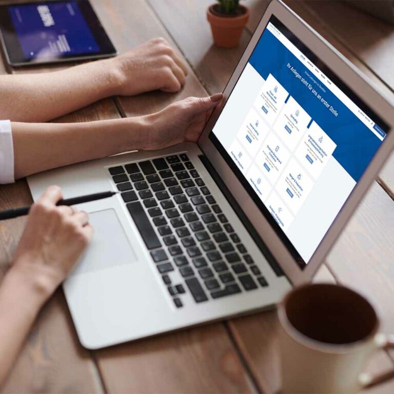 Personen vor einem Laptop betrachten die neue Webseite von Nekes & Partner